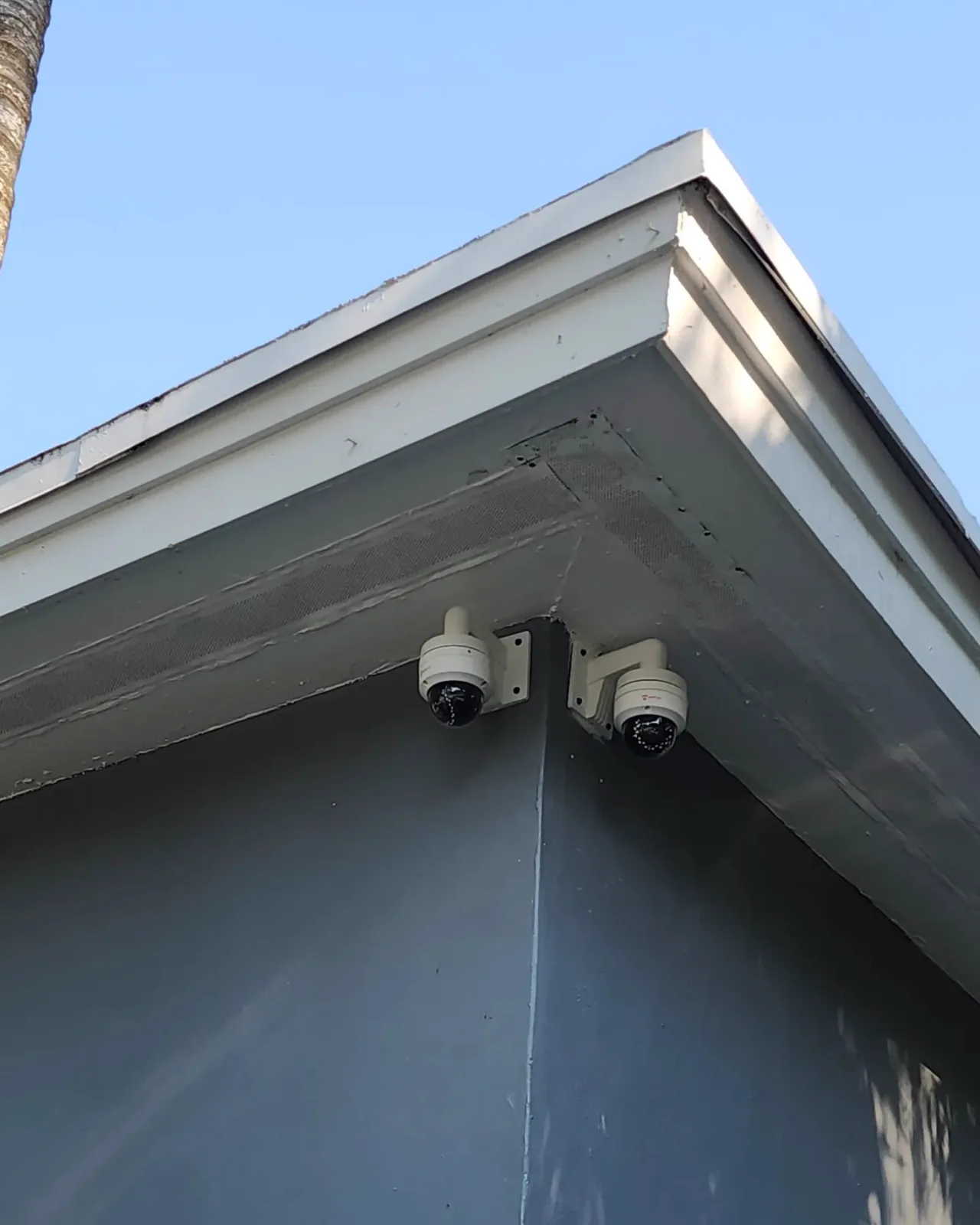 Two cameras installed under a roof corner